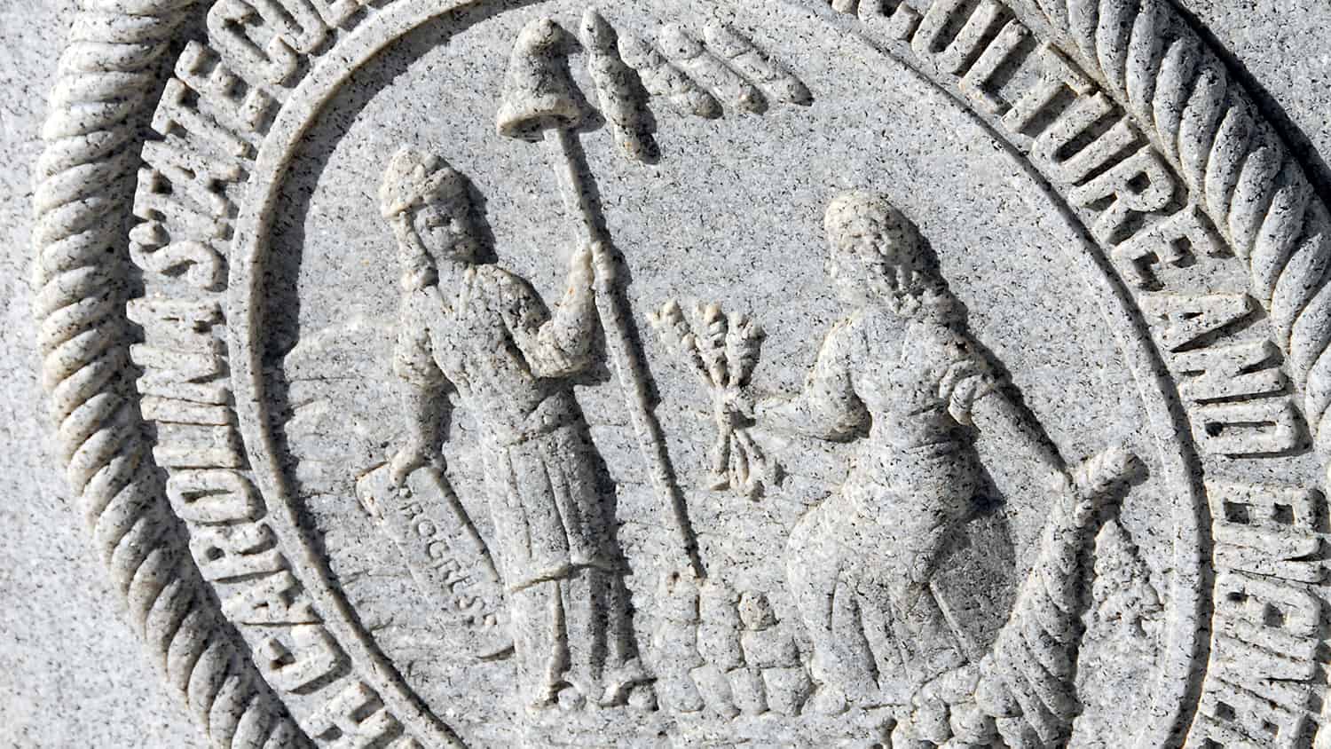 NC State University's seal etched in stone on the Memorial Belltower.